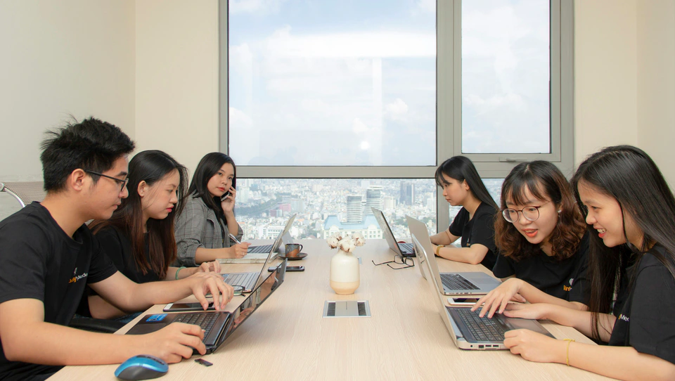 A Vietnamese agency team working together around a shared table.